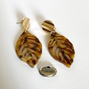 Boucles d'oreilles en acetate brune marbrée représentant une feuille nervurée et montée sur un clou d'oreille rond ondulé doré