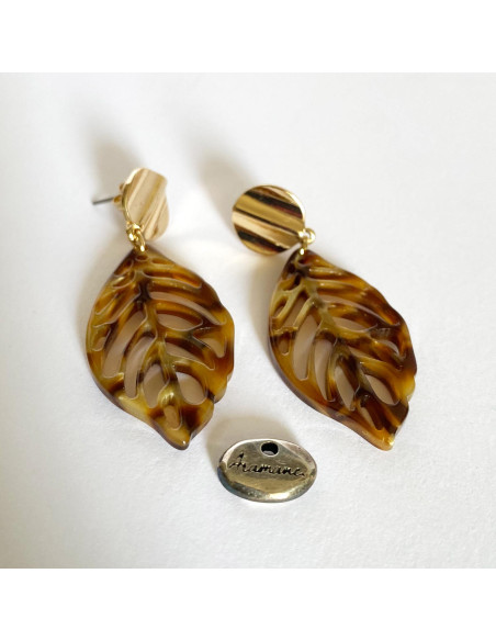 Boucles d'oreilles en acetate brune marbrée représentant une feuille nervurée et montée sur un clou d'oreille rond ondulé doré