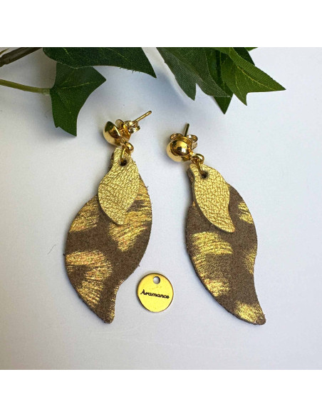 Boucles d'oreilles cuir forme flamme, motif empreintes dorées sur fond brun. Montées sur clou laiton doré